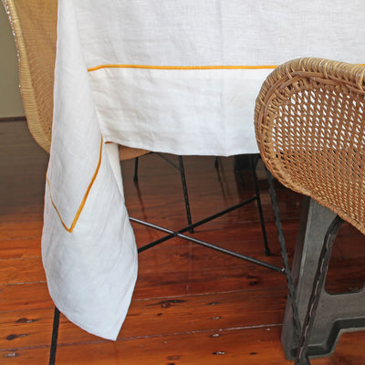 100% linen tablecloth with bourdon border #colour_optic-white